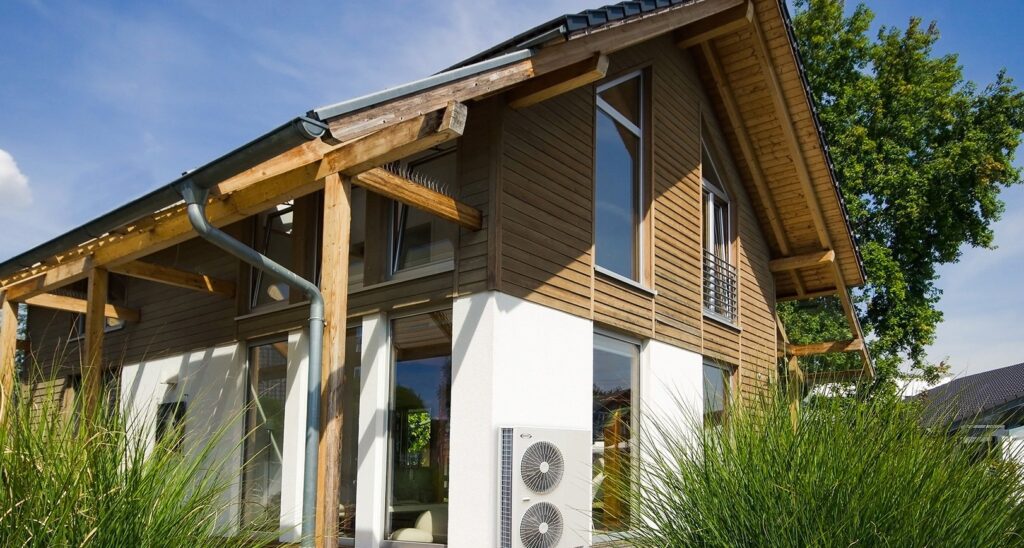 Eco-friendly house with solar panels and wooden exterior design.