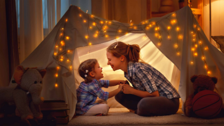 Indoor play tent with warm fairy lights and children playing inside.