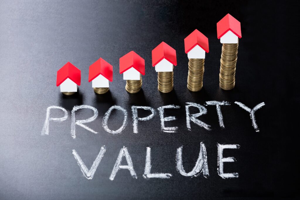 Increasing property value represented by stacked coins and red house icons.