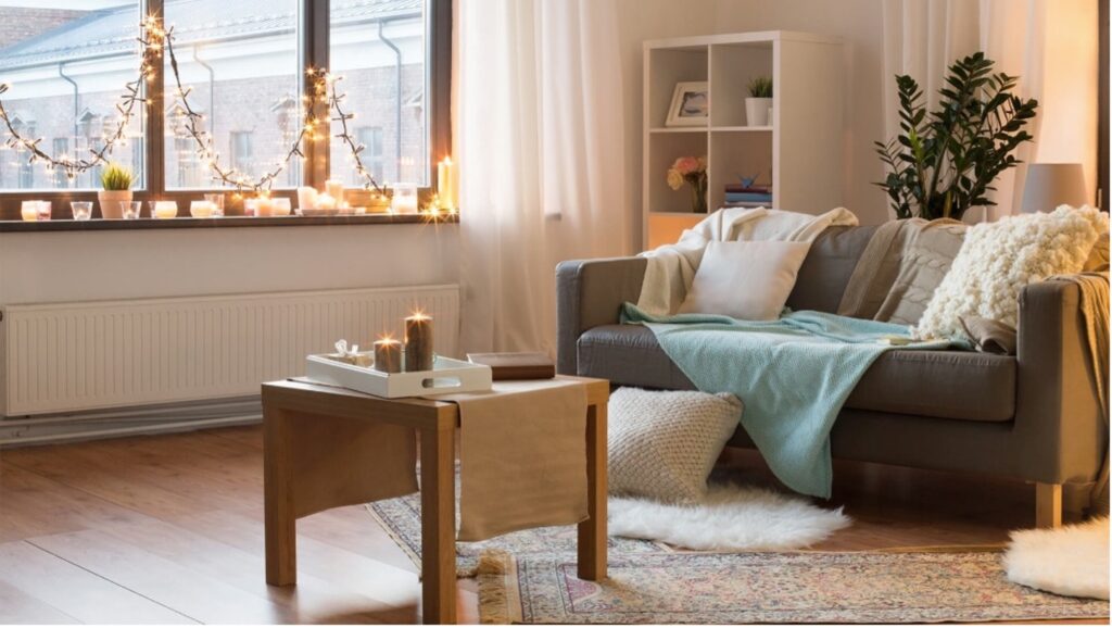 Cozy living room featuring a grey sofa, soft cushions, and a coffee table illuminated by warm natura.