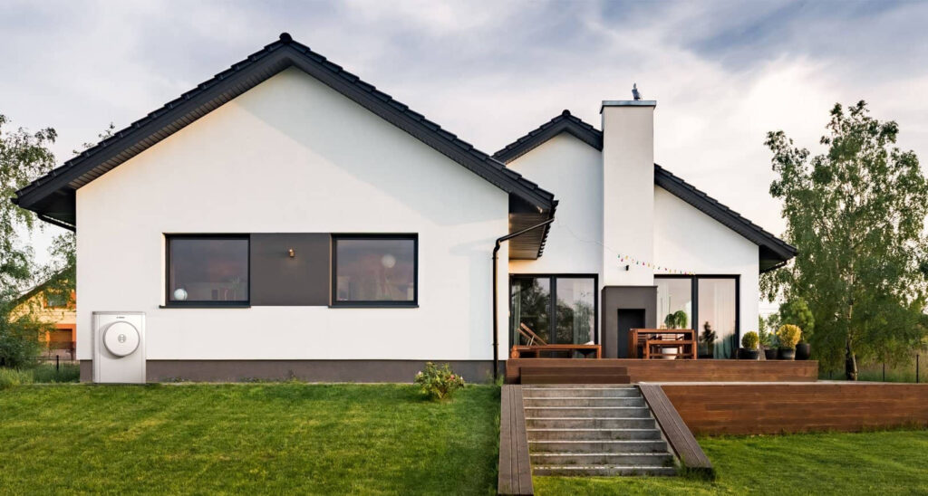 Contemporary white house featuring solar panels and a landscaped garden.