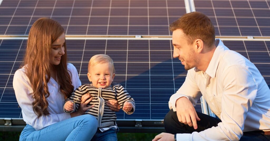 Family enjoying time near solar panels, promoting renewable energy benefits.