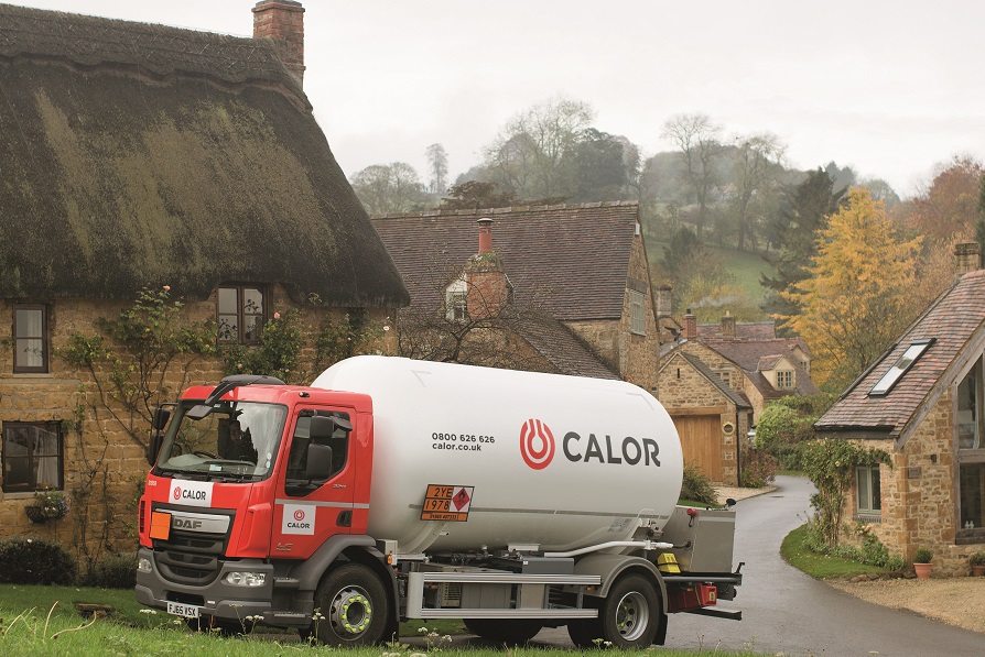 Calor delivery truck parked in a rural village with traditional cottages.